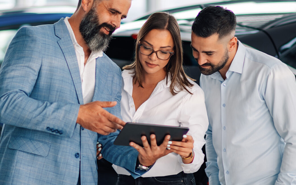 3 dealership employees Looking at a tablet