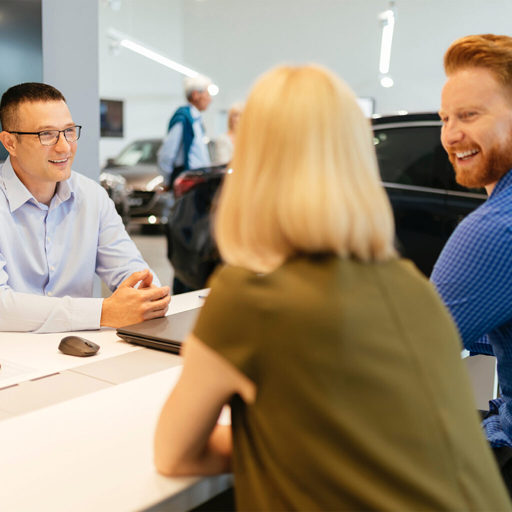 Car salesman talking with customers