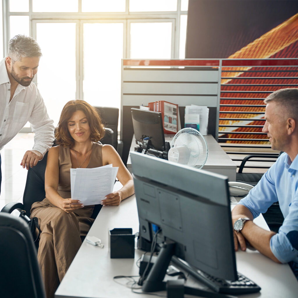 Man and woman look over paperwork at dealership.