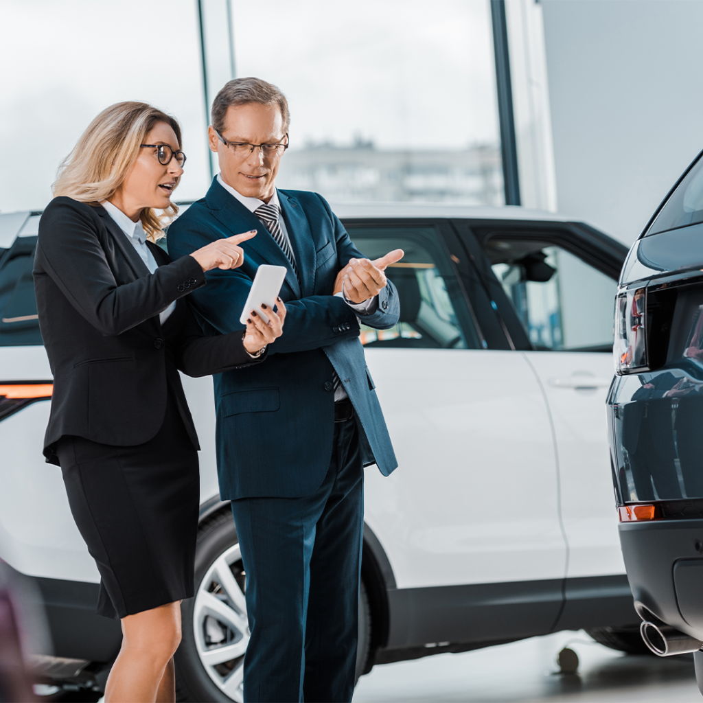 Business man and woman looking at a vehicle.