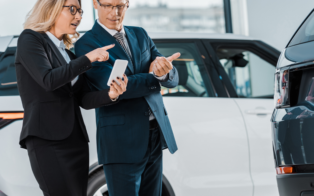Business man and woman looking at a vehicle.